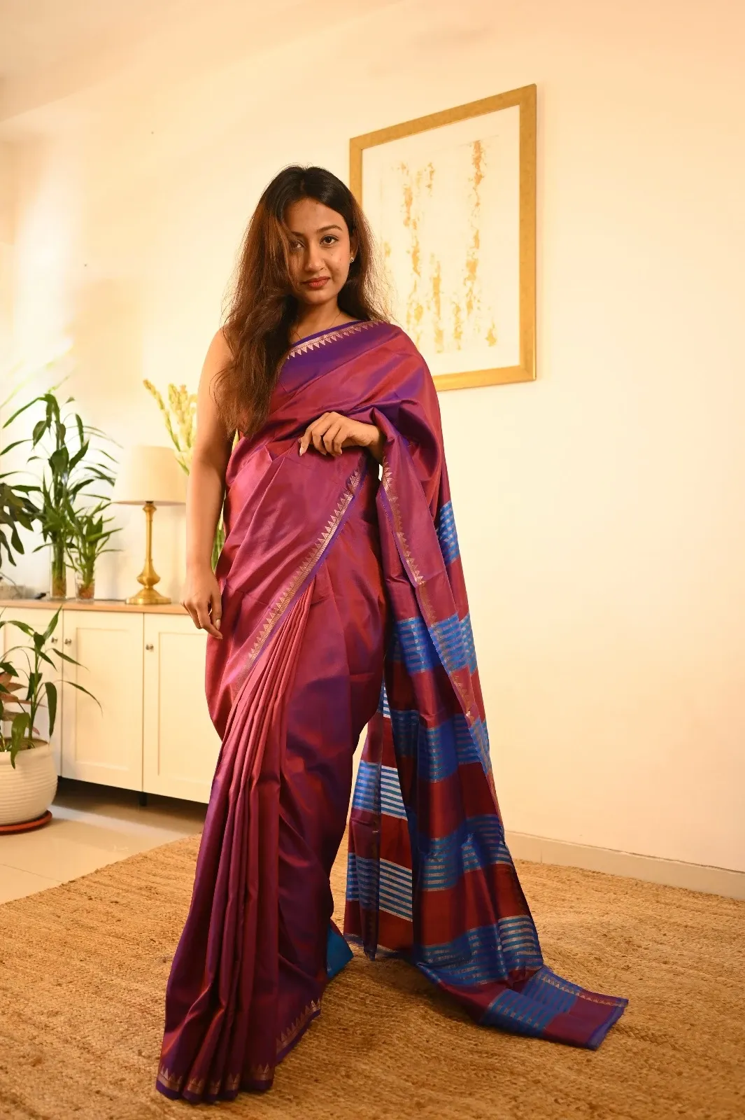 Woman wearing a dual tone maroon purple katan silk saree with a temple border