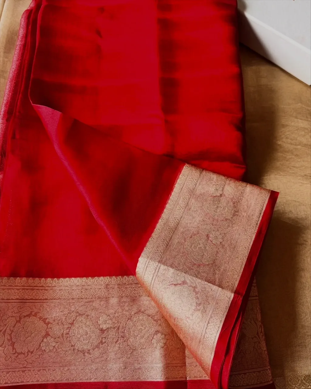 The red brocade border turned back on the folded saree
